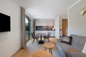 Ein modernes Wohnzimmer mit einer Couch, einem Couchtisch und einem Esstisch mit Stühlen.