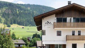 Un edificio de varios pisos con vistas a la montaña, un balcón y un letrero que indica que es un hotel.