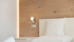 A hotel room with a wooden headboard, a bedside lamp, and neatly folded white towels. - Premium Apartment Hofer Elisabeth – Fast Internet, Free Parking (Niederdorf)
