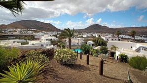 A coastal town with white buildings, a pool, and mountains in the background. - Holiday Home Casa Consultorio with Mountain View, Pool, Wi-Fi & Terrace (GUATIZA)