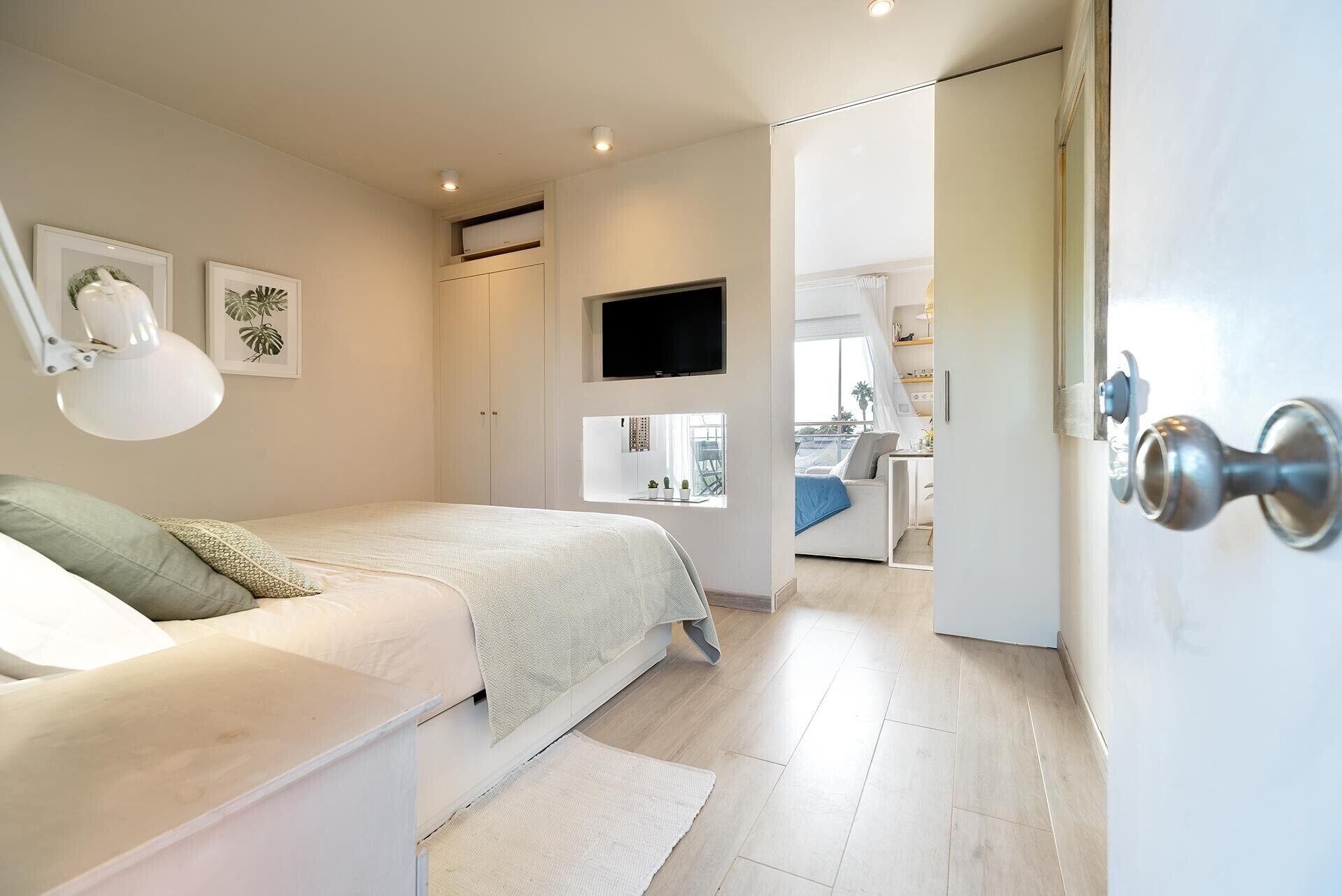 Un dormitorio con cama, escritorio, silla, televisor y armario.