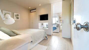 Un dormitorio con cama, escritorio, silla, televisor y armario.
