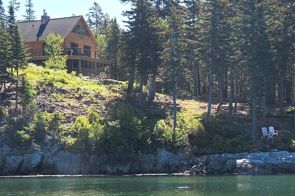 Log cabin above the water overlooking the ocean.
