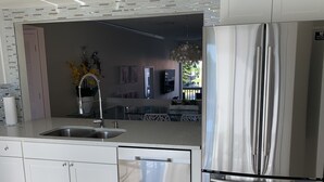 A modern kitchen with stainless steel appliances, a dishwasher, and a glass-top island. - Our house at the beach Most see<br>At siesta key  (Siesta Key)