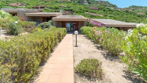 A pathway leading to a building with a tiled roof, surrounded by greenery and hills in the background. - Vacation home Cisto by Interhome (Costa Paradiso)