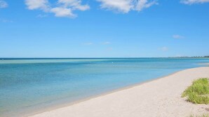 Een strand met helderblauw water en een zandstrand.