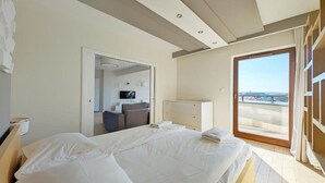 Une chambre d’hôtel moderne dotée d’un grand lit, d’un bureau et d’un balcon avec vue.