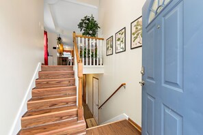 Stairs lead to an upper level with a door and a potted plant.