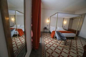 A hotel room with a four-poster bed, a chair, a small table, and a mirror. - 20 Miglia Boutique Hotel (Catania)
