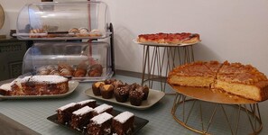 Un buffet proposant une variété de desserts, notamment des gâteaux, des pâtisseries et une grande tarte.