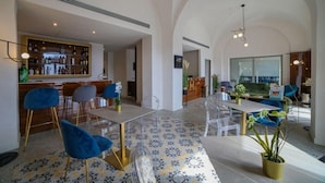 A spacious dining area with a bar, clear chairs, and a patterned floor.