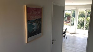 Ein Zimmer mit einer Tür, die auf einen Balkon führt.