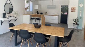 A modern kitchen with white cabinets, a wooden countertop, and a built-in oven.