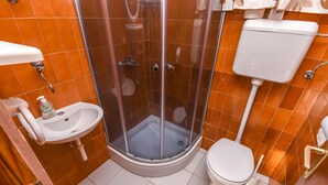 Ein kleines Badezimmer mit Dusche, Toilette und Waschbecken.