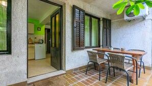 Una cocina con pared verde, refrigerador blanco y cafetera.