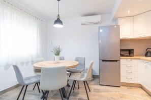 Een moderne keuken met een roestvrijstalen koelkast, een magnetron en een koffiezetapparaat op het aanrecht.
