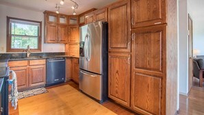 A kitchen with wooden cabinets, stainless steel appliances, and a window. - Spacious home in the South Hills of Missoula with a great view. (Missoula)