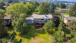 A residential property with a large deck, a fenced yard, and a view of surrounding hills. - Spacious home in the South Hills of Missoula with a great view. (Missoula)