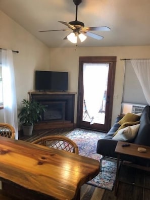 Relax in this inviting living room with a dining table, comfortable sofa, and large window.