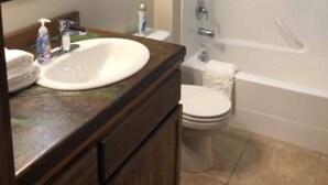 A bathroom with a sink, mirror, toilet, and bathtub. - Cozy condo located in central Missoula on the Milwaukee Path bike trail. (Missoula)