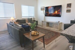 Una sala de estar con sofá, mesa de centro y televisor.