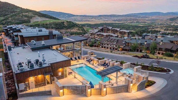 Un resort con piscina, area salotto esterna e vista sul paesaggio circostante.