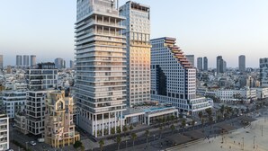 Un moderno edificio de gran altura con múltiples pisos, amplias ventanas y un diseño arquitectónico único.