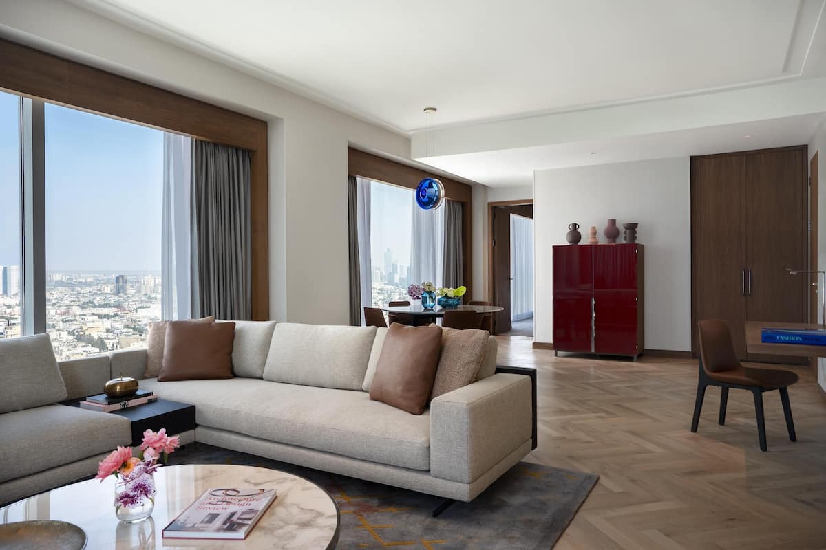 Un salon moderne comprenant un canapé, une table basse et un coin repas avec un buffet rouge et une chaise.