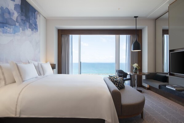 A hotel room with a large bed, a sofa, a TV, and a view of the ocean. - The David Kempinski Tel Aviv (Tel Aviv)