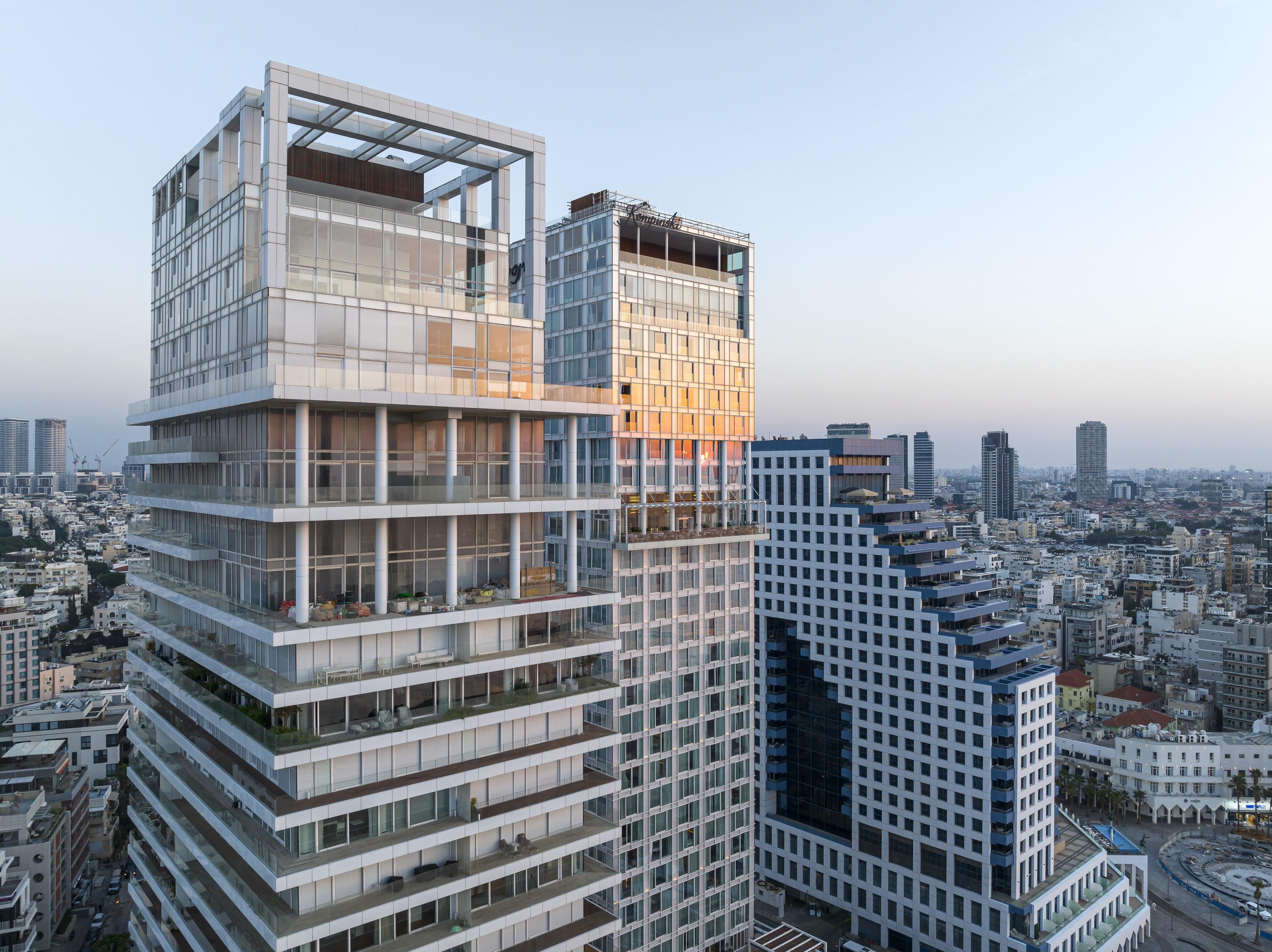 Un moderno edificio de gran altura con varios balcones y ventanas amplias.