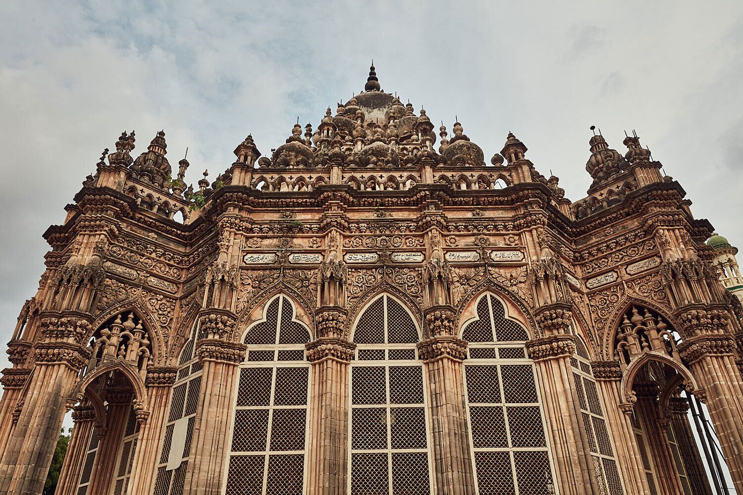 Un edificio grande y ornamentado, con elaboradas esculturas y varias ventanas de arco.