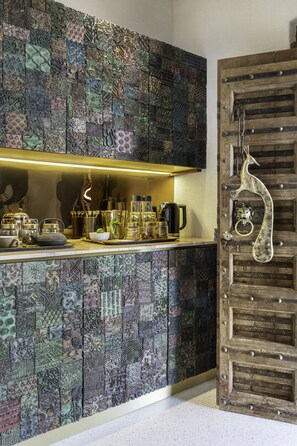 A kitchen with a patterned backsplash and a wooden door with a decorative handle. - Aramness Gir National Park (Mendarda)