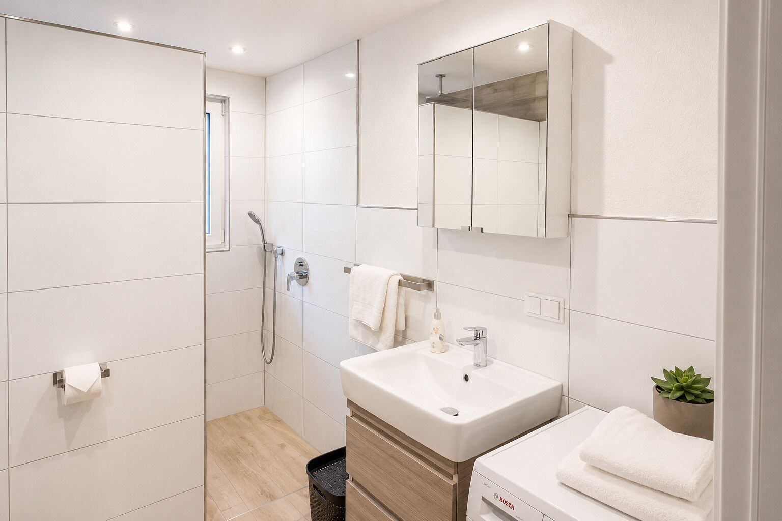 A modern bathroom with a shower, sink, and mirror.