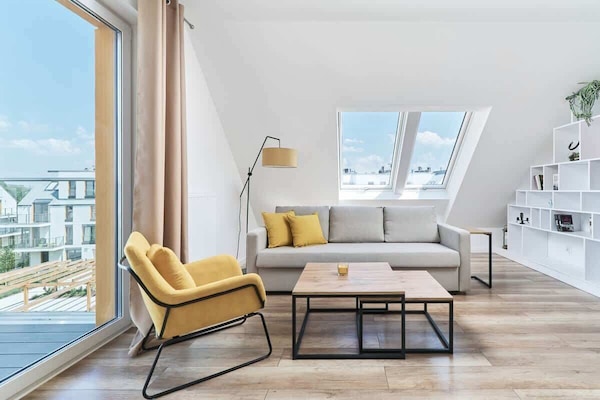 A bright living room with a skylight, modern furniture, and a cozy yellow armchair, creating a welcoming atmosphere.