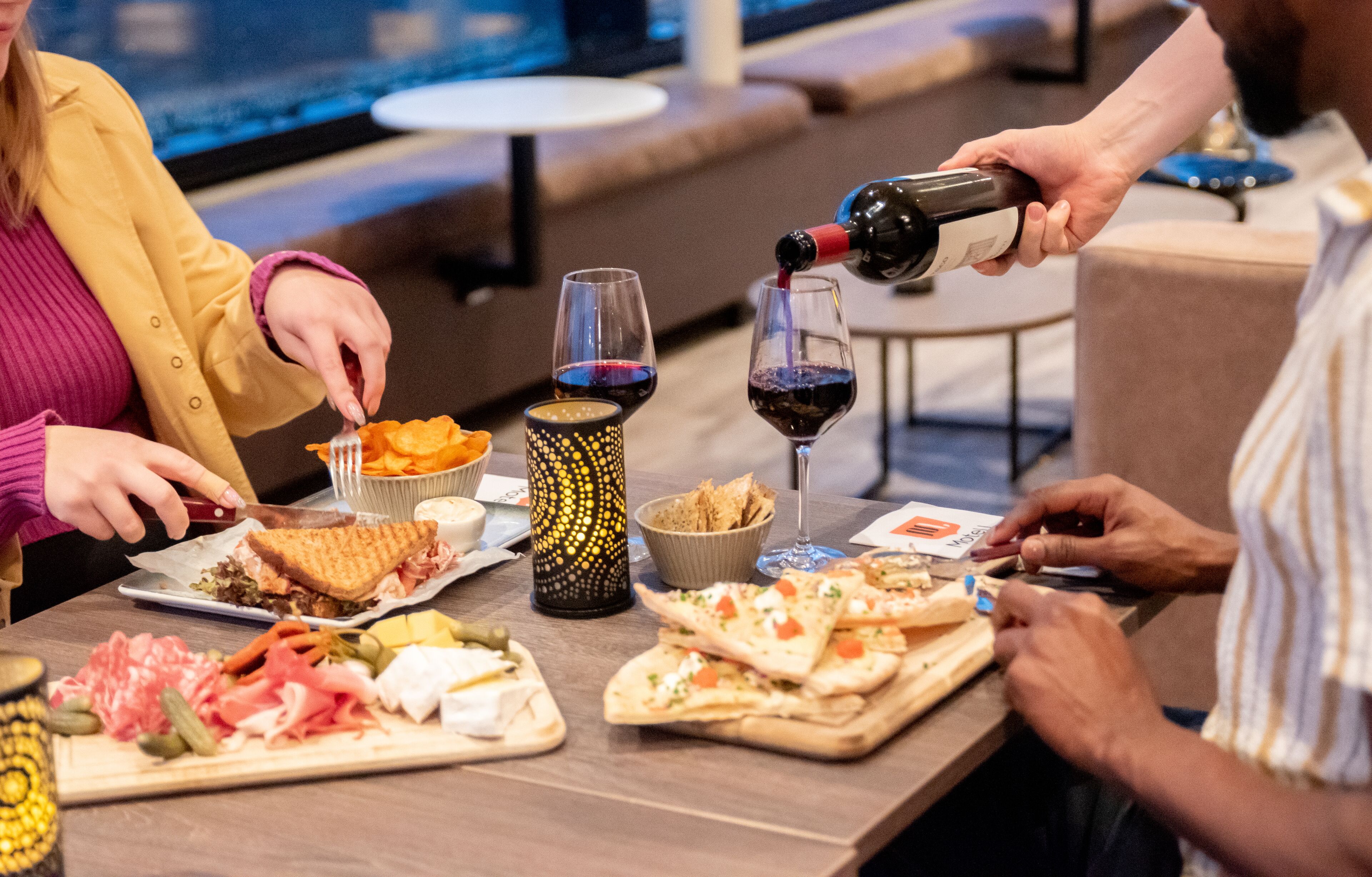 Une table à manger avec divers plats et des verres à vin.