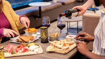 A dining table with various food items and wine glasses.