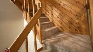 A wooden staircase with carpeted steps and a handrail. - Mountain gateway in the beautiful Lake Harmony (lake harmony)
