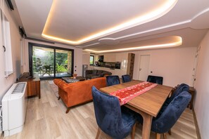 Ein moderner Essbereich mit einem Holztisch, blauen Samtstühlen und einer roten Tischläufer.