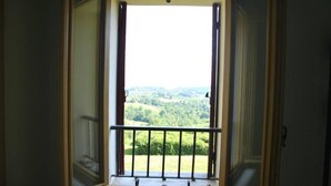A room with a window overlooking a green landscape. - La Torre di Rua (SAN PIETRO DI FELETTO)