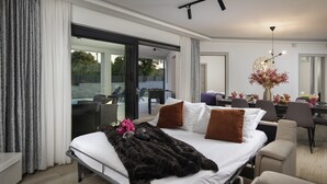 A modern hotel room with a large bed, a dining area, and a view of the outdoors. - Villa Speranza with pool (Pula)