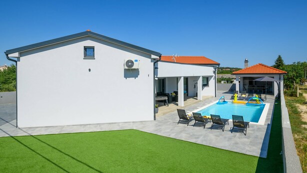 A modern house with a swimming pool, a covered patio, and a well-maintained lawn. - Villa Speranza with pool (Pula)