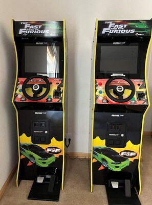 Two arcade machines with 'The Fast and the Furious' branding, featuring a steering wheel, buttons, and a car graphic.