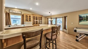 A kitchen with a large island, wooden cabinets, and a view of a lake.