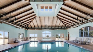 Una amplia piscina interior con techos altos y luz natural que entra por grandes ventanales.