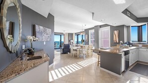 Una cocina amplia con comedor, ventanas grandes y vista al océano.
