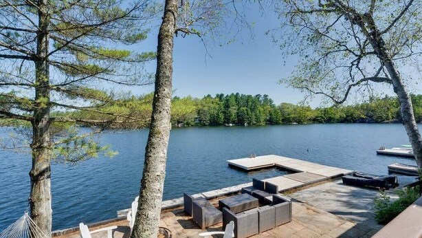 Une terrasse au bord du lac, avec des sièges extérieurs et un quai.