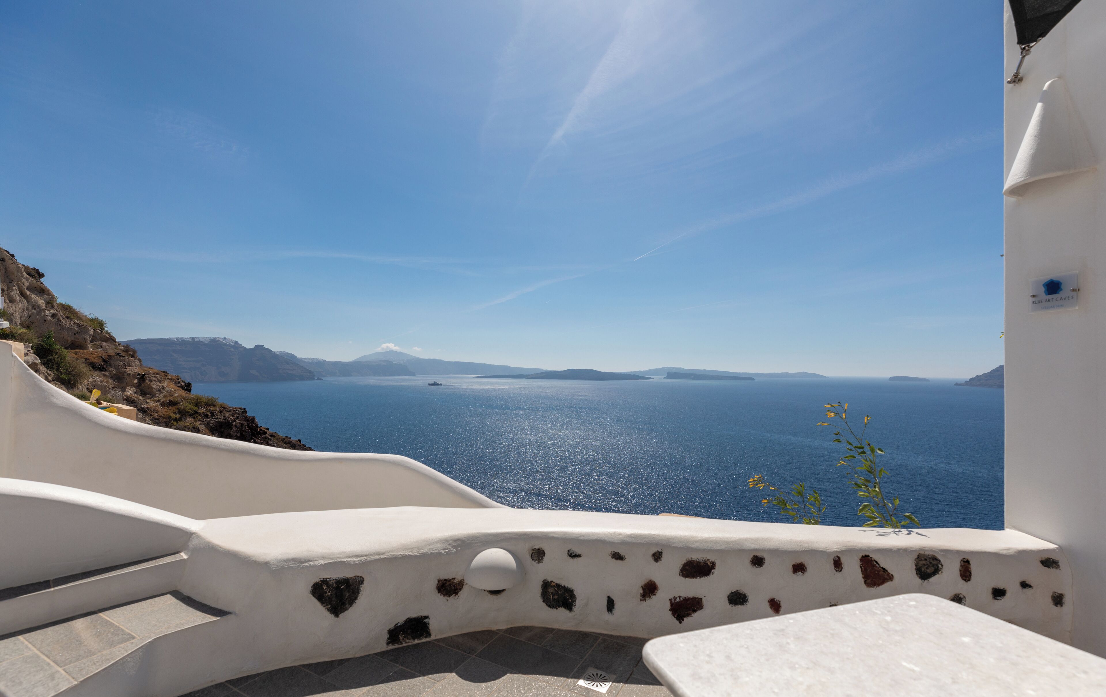 Un bâtiment blanc doté d’un sol carrelé en pierre et offrant une vue sur la mer.