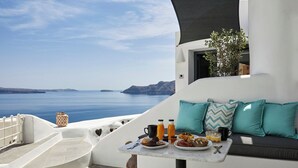 Varanda com mesa posta para café da manhã, com vista panorâmica para o mar e ilhas.