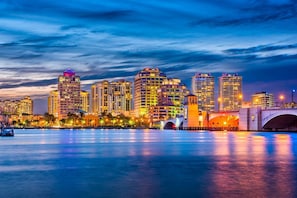 A city skyline with high-rise buildings, a bridge, and a calm waterfront.