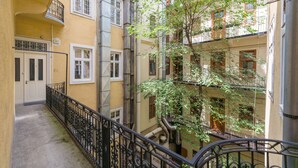 En byggnad med flera våningar, balkonger, en central trappa och ett träd på innergården.